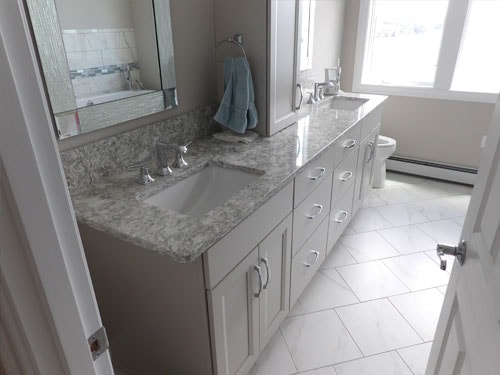 Master bath vanity with gray cabinets, granite countertop, and large tile floor