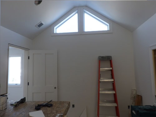 Vaulted ceiling great room with triangular gable windows and fresh drywall finish