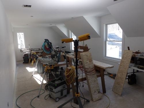 Bonus room with dormers and skylights under construction with miter saw setup
