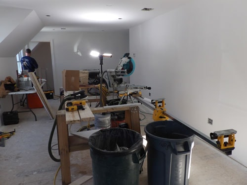 Finish carpentry in progress in bonus room with recessed lighting and sloped ceiling
