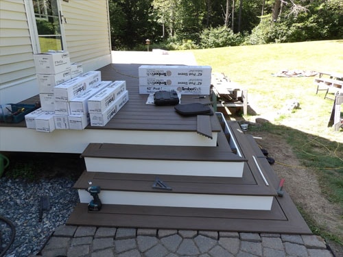 TimberTech composite deck stairs under construction with brown decking boards and white skirting