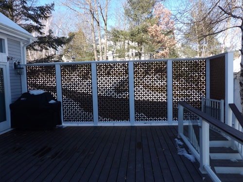 Completed deck with decorative diamond lattice privacy screen panels, white railings, and Weber grill