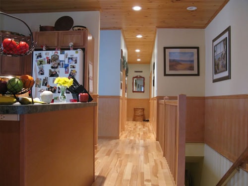 Finished kitchen and hallway with knotty pine tongue-and-groove ceiling, beadboard wainscoting, maple hardwood flooring, and recessed lighting