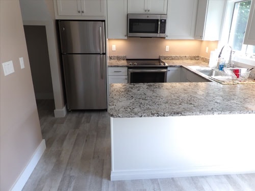 Kitchen remodel with granite island and stainless appliances