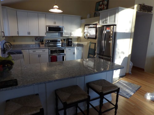 Bright kitchen with granite island and bar stools