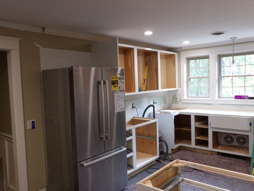 Kitchen remodel mid-construction with new refrigerator