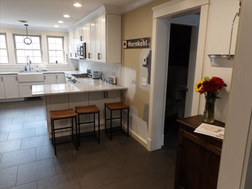 Bright kitchen remodel with white cabinets, quartz island, and bar stools