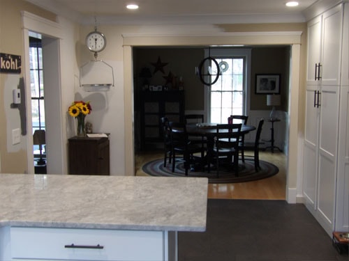 Kitchen open to dining room with quartz island and white cabinetry