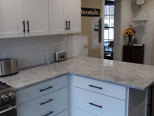 Quartz countertop detail with subway tile backsplash and black hardware